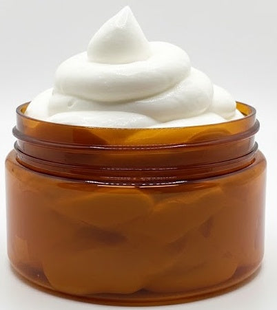 whipped creamy white lotion piled high in an amber colored jar