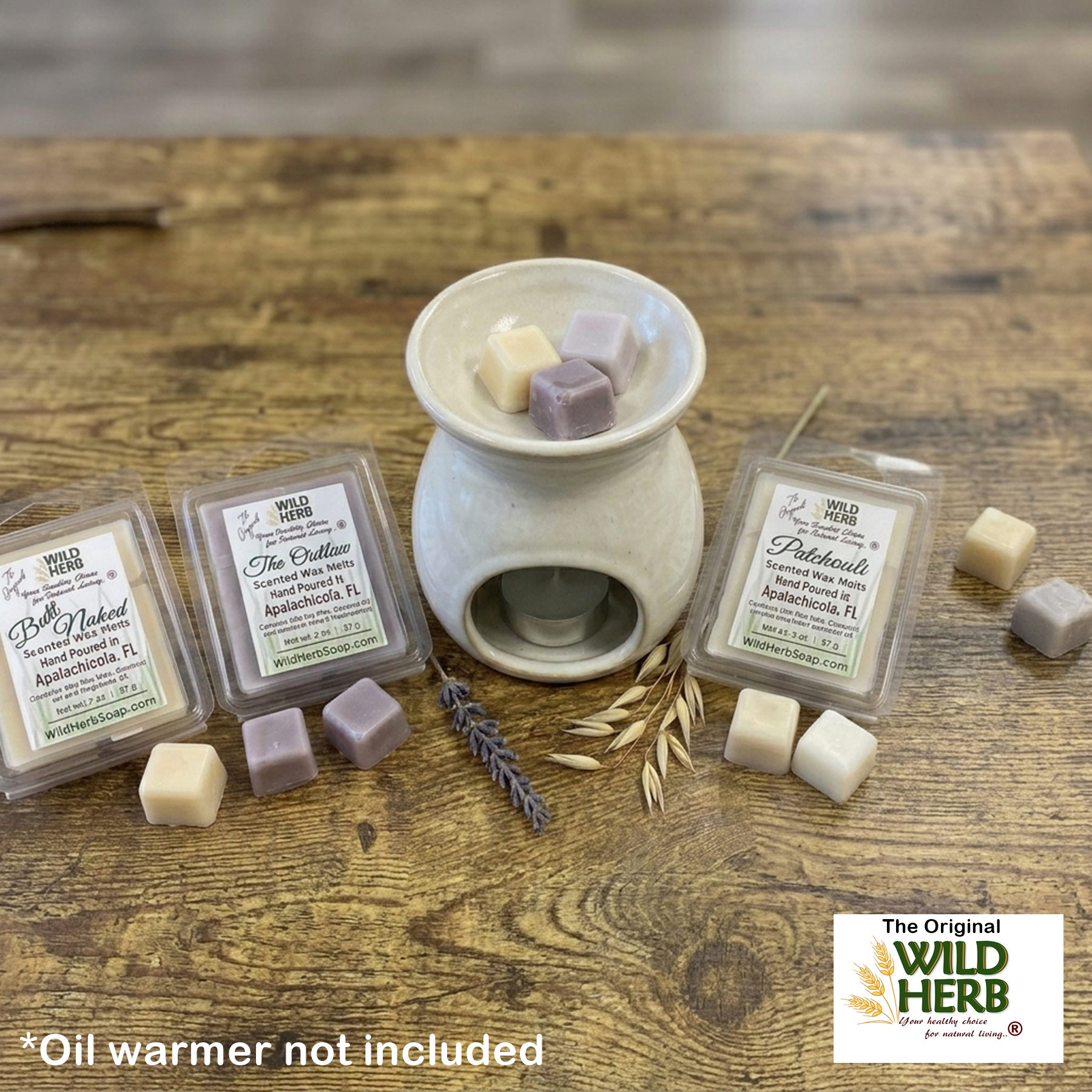 Wax melts and oil warmer on a wooden surface with Wild Herb branding.