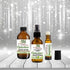 Three bottles of Wild Herb Aphrodisiac essential oil blend on a wooden surface with a sparkling background.