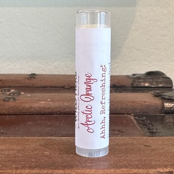 A clear plastic tube of lip balm with a white label reading &