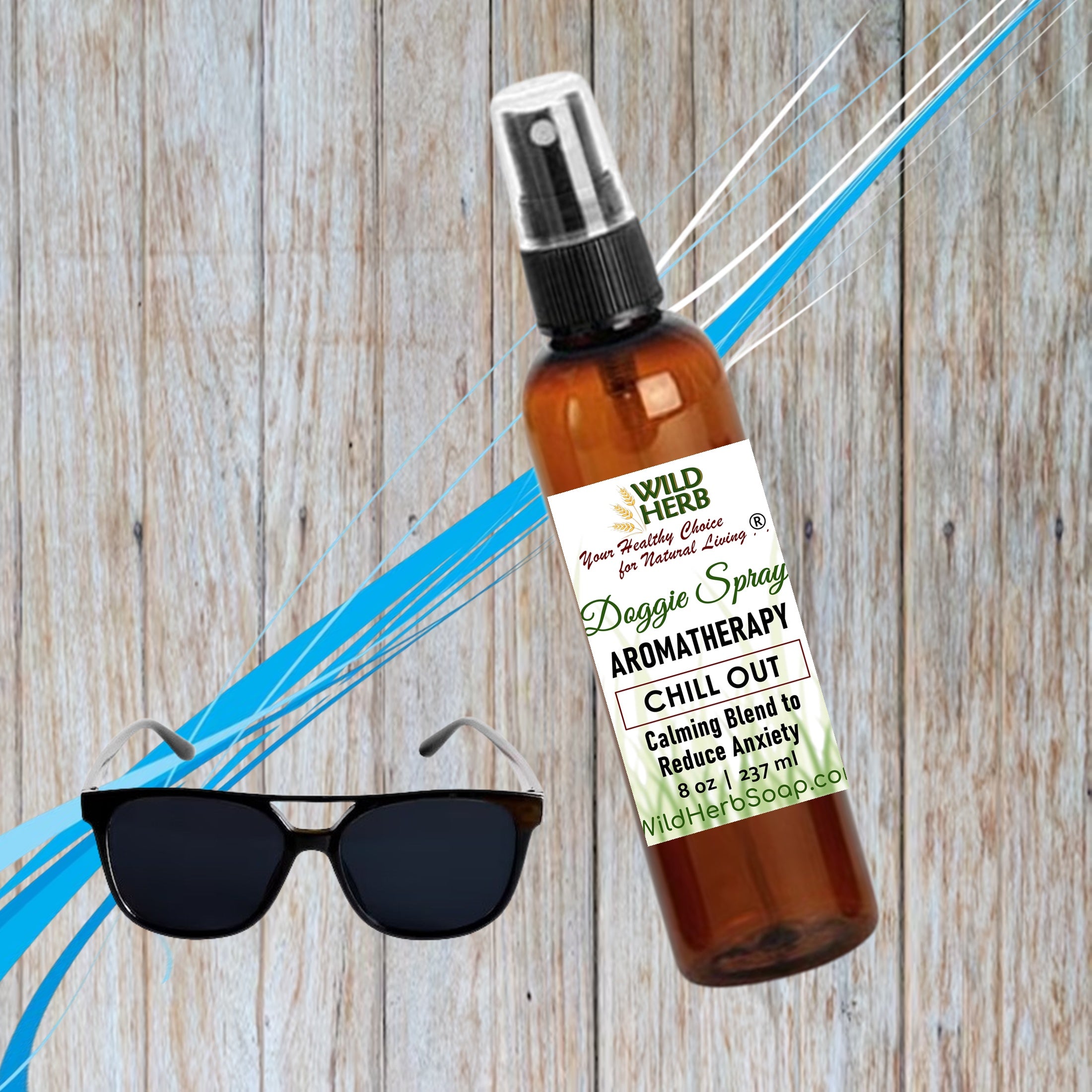 Brown spray bottle with label on a wooden surface with sunglasses below