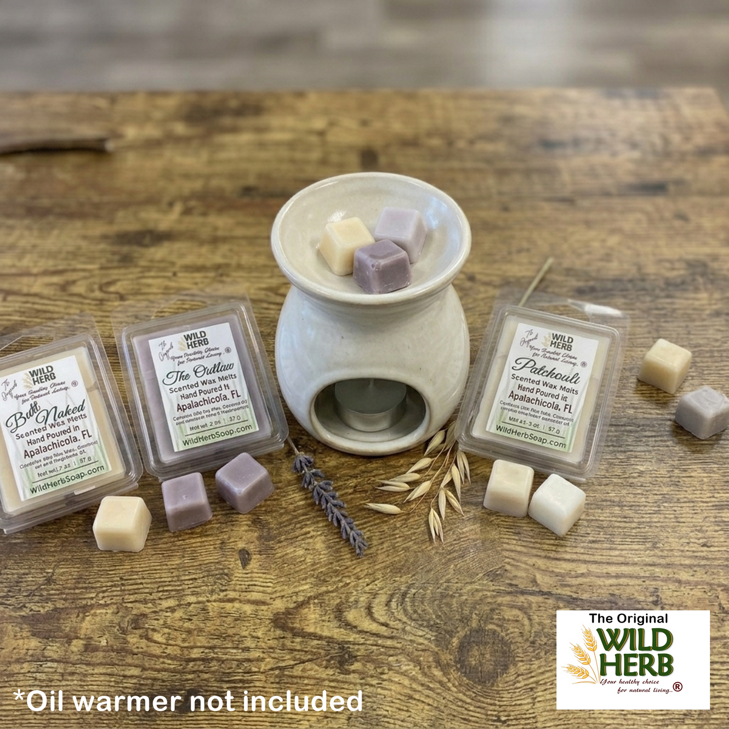Wax melts and oil warmer on a wooden surface with Wild Herb branding.