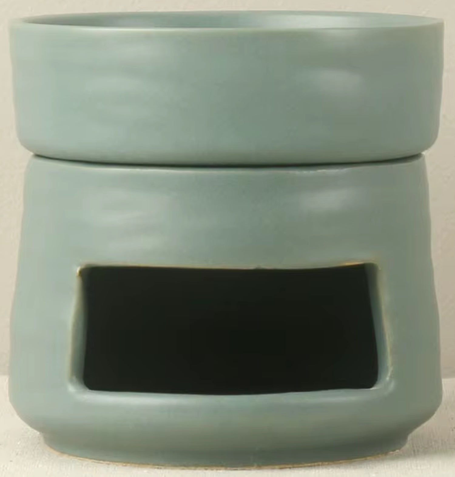 Sage green ceramic oil warmer and wax melt burner featuring a modern minimalist design, smooth matte finish, and a wide tea light cutout